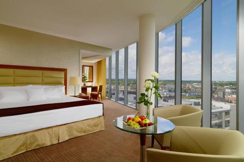 阿斯隆喜来登阿斯隆酒店的酒店客房,配有床和一张带水果的桌子