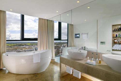 阿斯隆喜来登阿斯隆酒店的大型浴室设有两个盥洗盆和大镜子