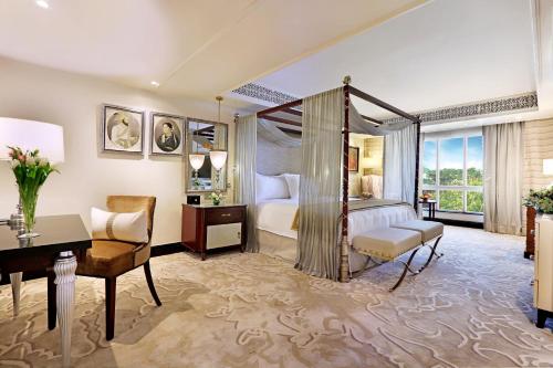 孟买ITC Maratha, a Luxury Collection Hotel, Mumbai的酒店客房配有一张床、一张书桌和一张书桌。