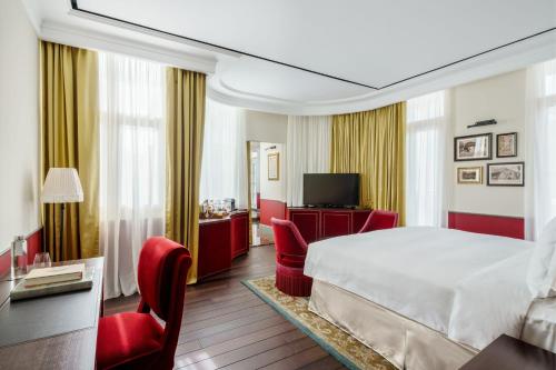 新加坡Maxwell Reserve Singapore, Autograph Collection的酒店客房,配有床铺和红色椅子