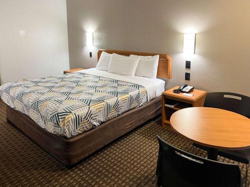 波特兰Motel 6 Portland OR Southeast的酒店客房配有一张床铺和一张桌子。