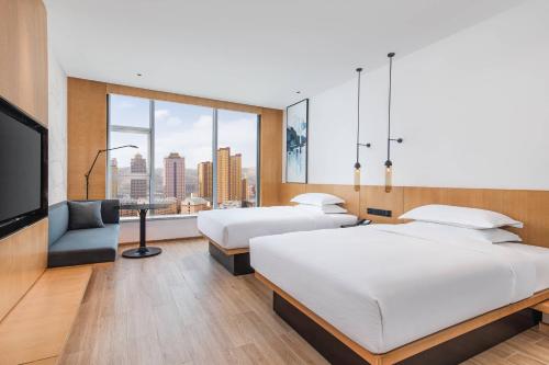 西宁西宁城北万枫酒店的酒店客房设有两张床和一台平面电视。