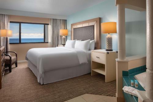 詹森比奇维斯塔纳海滩俱乐部酒店的卧室设有一张白色大床和大窗户