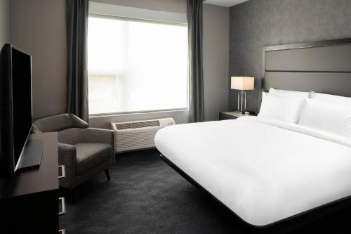 内蒂克Residence Inn by Marriott Boston Natick的酒店客房设有白色的床和窗户。