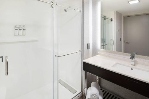 内蒂克Residence Inn by Marriott Boston Natick的带淋浴、盥洗盆和镜子的浴室