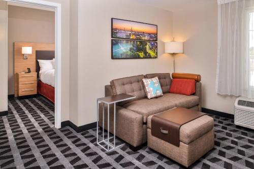 查尔斯顿TownePlace Suites by Marriott Charleston-West Ashley的客厅配有沙发和1张床
