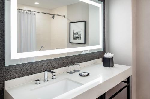 朴茨茅斯朴茨茅斯哈勃尔赛德喜来登酒店的浴室配有白色水槽和大镜子