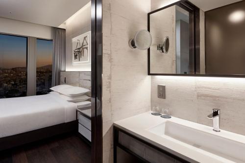 首尔首尔江南福朋喜来登酒店的浴室设有床、水槽和镜子
