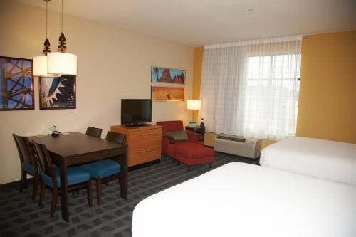 霍布斯霍布斯万豪广场套房酒店的酒店客房设有一张桌子、一张床和一间卧室。