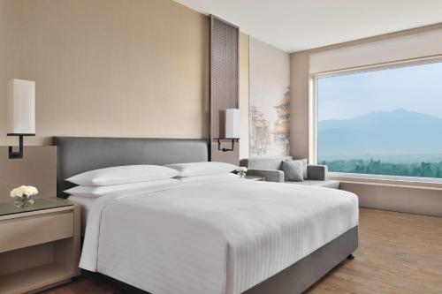 加德满都Kathmandu Marriott Hotel的卧室设有一张白色大床和大窗户