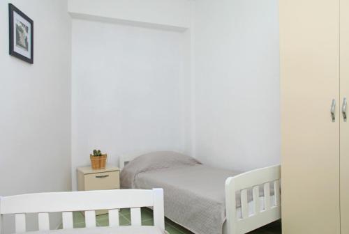 都拉斯Old town boulevard apartment in city center的一间卧室配有2张白色婴儿床和1张小床。