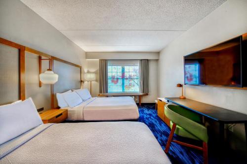 科特兰Fairfield Inn & Suites by Marriott Cortland的酒店客房配有两张床和一张书桌