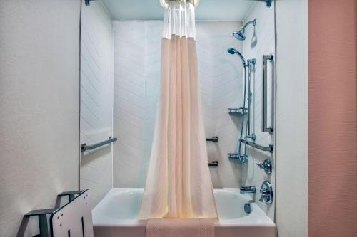 科特兰Fairfield Inn & Suites by Marriott Cortland的浴室配有淋浴帘和浴缸。