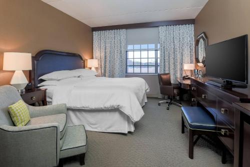 塔里敦塔里敦喜来登酒店的酒店客房配有一张床、一张书桌和一台电视。