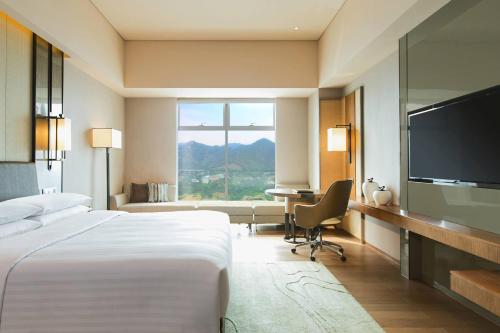 重庆重庆万豪酒店的酒店客房配有一张床、一张书桌和一台电视。