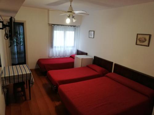 内科切阿Necochea Real Hotel的客厅配有3张红色沙发和1张桌子
