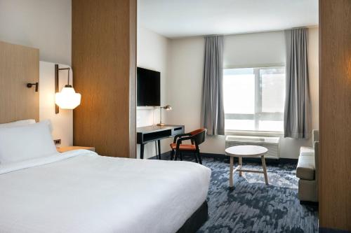 北湾Fairfield by Marriott Inn & Suites North Bay的配有一张床和一张书桌的酒店客房