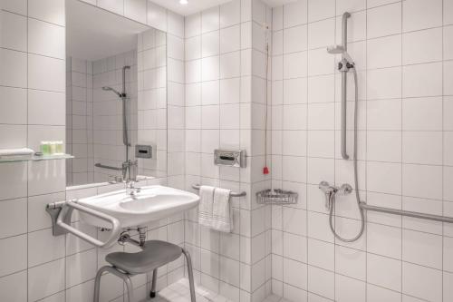 慕尼黑慕尼黑城市中心万豪酒店的白色的浴室设有水槽和淋浴。