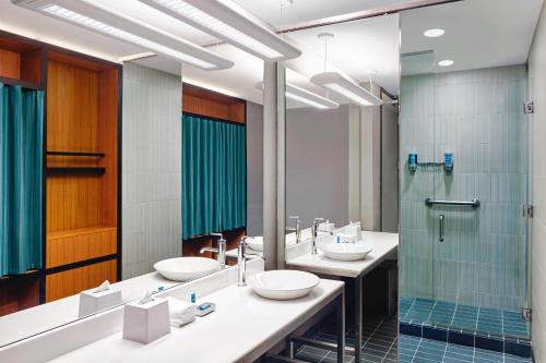 多瓦尔蒙特利尔机场雅乐轩酒店的一间带两个盥洗盆和淋浴的浴室