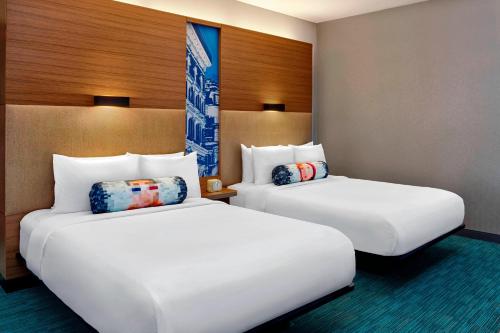 多瓦尔蒙特利尔机场雅乐轩酒店的两张睡床彼此相邻,位于一个房间里