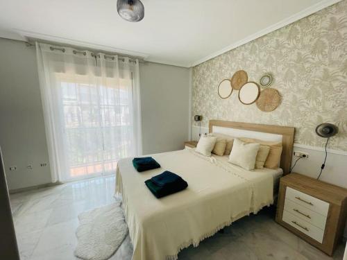 马贝拉Jolie maison à Cabopino Marbella的一间卧室设有一张大床和大窗户