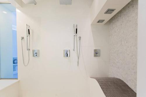 圣多明各复兴圣多明各雅拉瓜酒店&俱乐部的浴室配有白色墙壁和步入式淋浴间。
