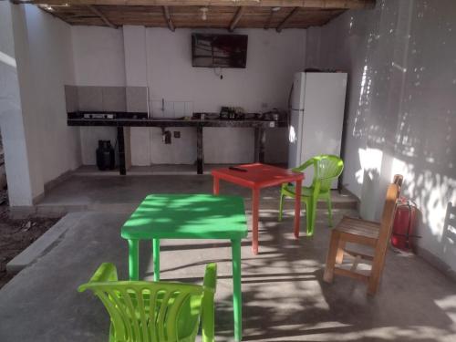 纳斯卡flying monkey hostel的厨房配有绿色和红色的桌椅