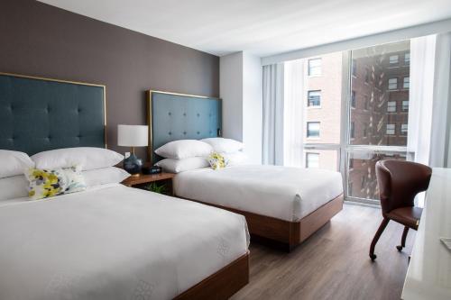 芝加哥Le Meridien Essex Chicago的酒店客房设有两张床和窗户。