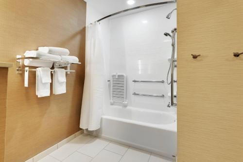 休斯顿休斯敦西北/威洛布鲁克费尔菲尔德酒店的带淋浴和白色毛巾的浴室