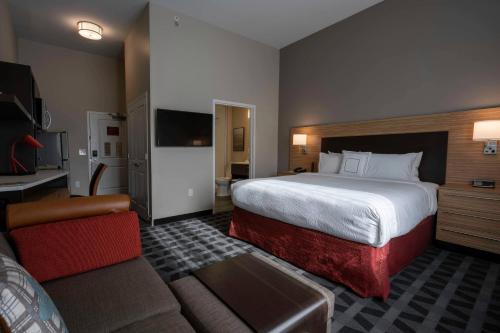 克林顿TownePlace Suites by Marriott Clinton的酒店客房设有一张大床和一张沙发。