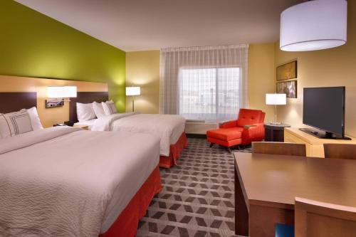 迪金森TownePlace Suites by Marriott Dickinson的酒店客房设有两张床和一台平面电视。