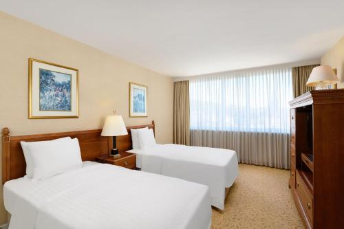 布达佩斯布达佩斯千禧万豪行政公寓的酒店客房设有两张床和窗户。