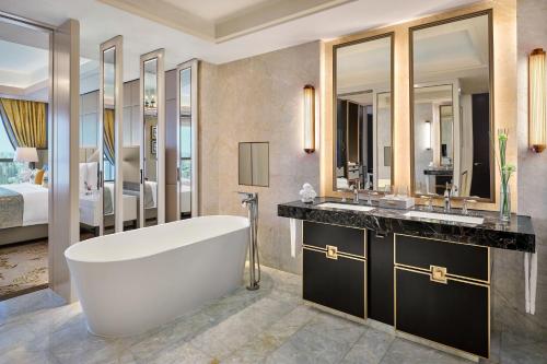 上海上海静安瑞吉酒店的带浴缸、两个盥洗盆和床的浴室