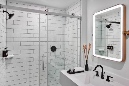 罗利The Casso, Raleigh, a Tribute Portfolio Hotel的白色的浴室设有水槽和镜子