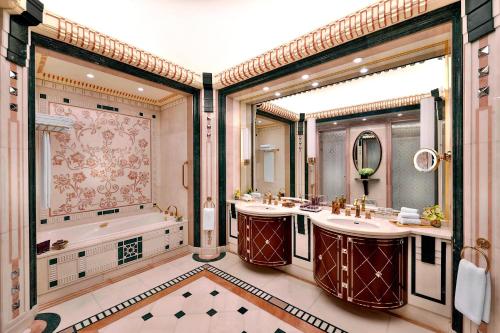 吉达吉达丽思卡尔顿酒店 的一间带两个盥洗盆和浴缸的浴室以及大窗户。