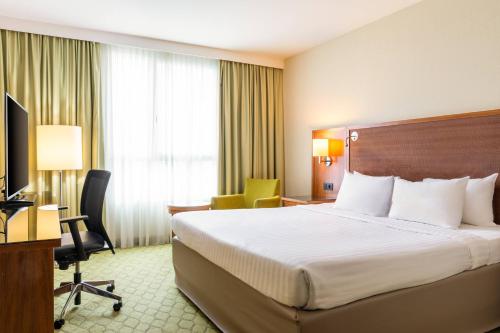 圣但尼巴黎圣但尼万怡酒店的配有一张床和一张书桌的酒店客房