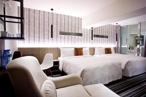 台北丰居旅店-忠孝馆的酒店客房,设有两张床和一张沙发