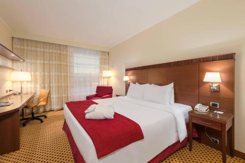 泰塞拉万豪威尼斯机场酒店的酒店客房设有一张大床和一张书桌。