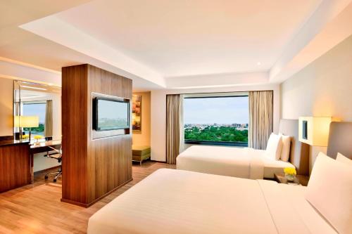 钦奈金奈万豪酒店的酒店客房设有两张床和窗户。