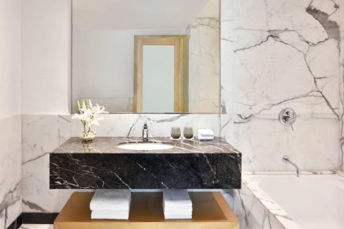 钦奈金奈万豪酒店的一间带大理石盥洗盆和浴缸的浴室