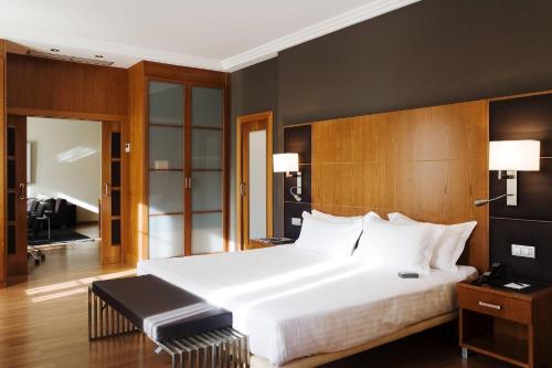 阿尔么丽亚AC Hotel Almería by Marriott的卧室配有一张白色大床和木制床头板