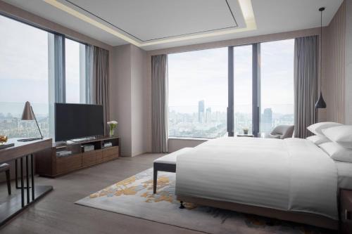 苏州苏州合景万怡酒店的卧室配有一张白色大床和电视。
