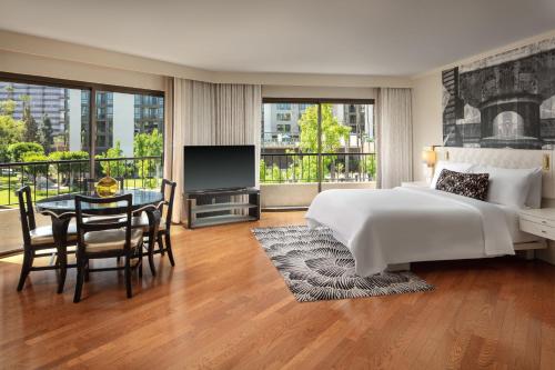 科斯塔梅萨科斯塔梅萨艺术大道酒店 - 翠贡精选酒店的一间卧室配有一张床、一张桌子和一台电视