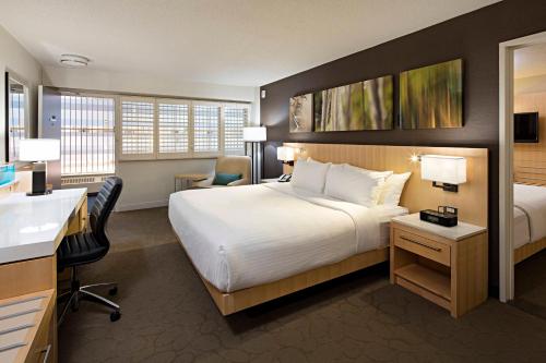 温尼伯三角洲温尼伯酒店的酒店客房设有一张大床和一张书桌。