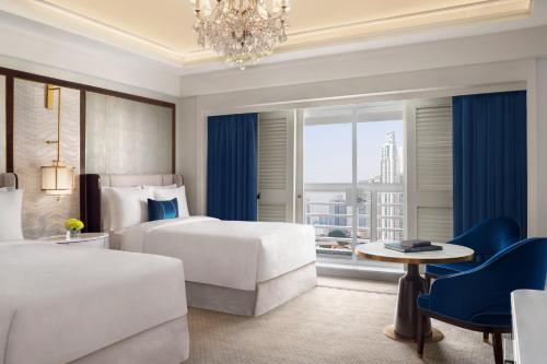 雅加达The St. Regis Jakarta的酒店客房设有两张床和吊灯。