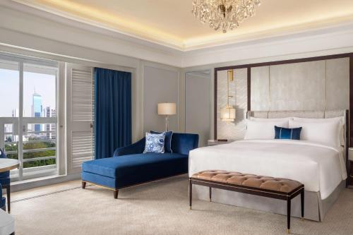 雅加达The St. Regis Jakarta的一间卧室配有一张大床和一张蓝色椅子