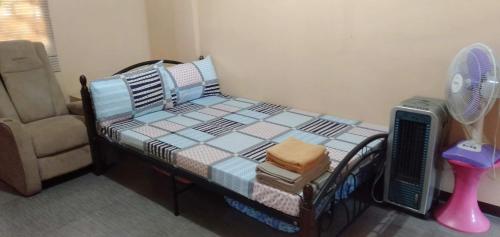 安吉利斯雷蒙过客之家旅馆的一间卧室配有一张带风扇和椅子的床。