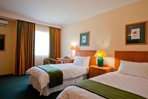 温当瓦翁丹瓜普罗蒂亚酒店的酒店客房设有两张床和窗户。