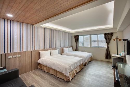 花莲市天璽商務飯店 Cullinan Hotel的酒店客房设有两张床和电视。