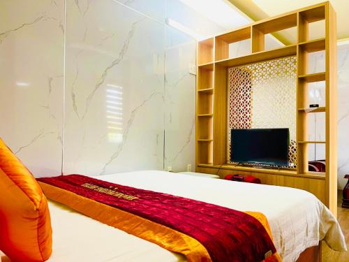 Quảng TrịKhách sạn Khánh Phương的一间卧室配有一张床和一台平面电视